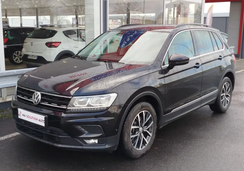 Volkswagen Tiguan noir nacré 2019 en 3/4 avant droit, avec jantes alliage et feux LED allumés.