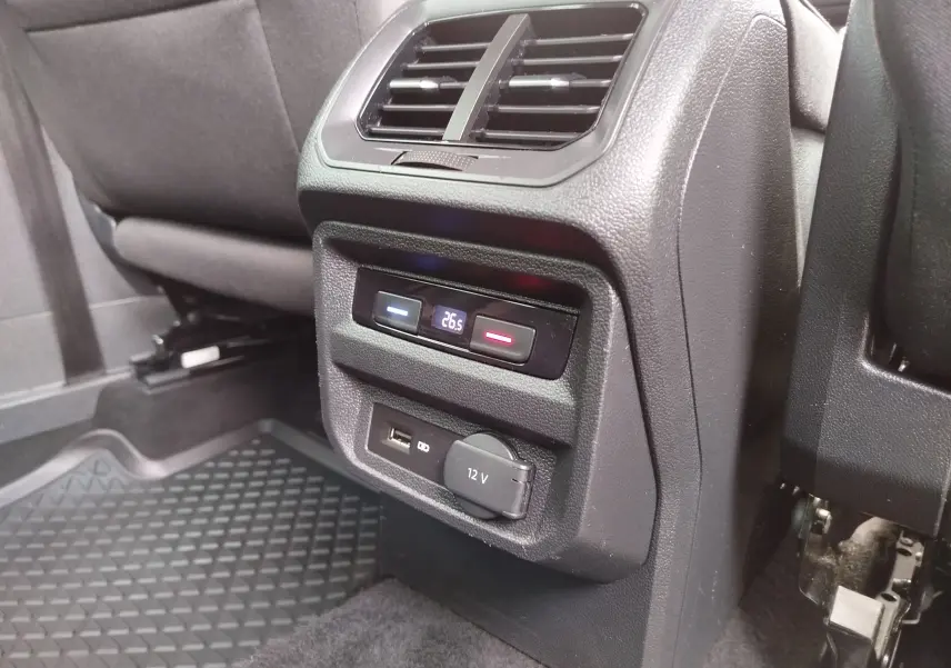 Détail de la console arrière noire du Volkswagen Tiguan 2019 avec réglage de climatisation à 26,5°C et prises USB et 12V.