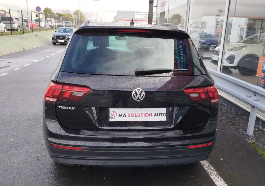 Vue arrière d'un Volkswagen Tiguan noir intense nacré de 2019, avec feux arrière LED et logo VW bien visibles.