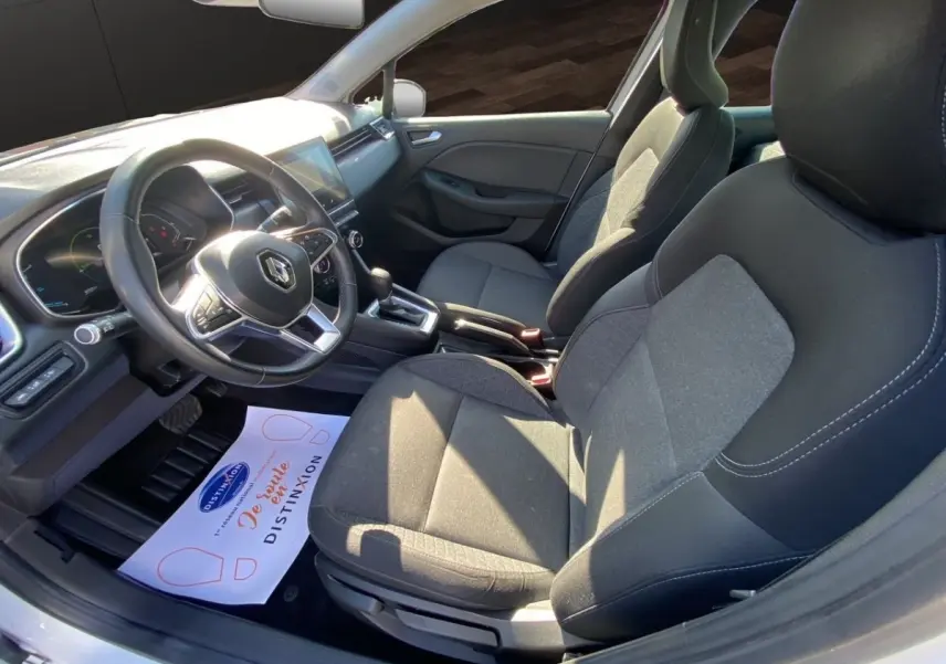 Vue intérieure côté conducteur de la Renault Clio Business E-TECH 140 2021, sièges gris et volant multifonctions cuir synthétique.