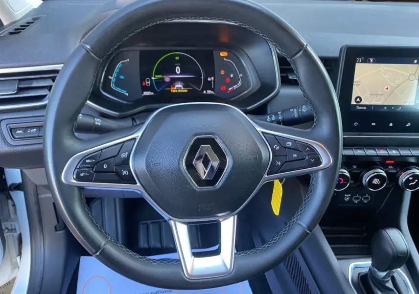 Vue intérieure centrée sur le volant cuir noir de la Renault Clio Business E-TECH 140 avec tableau de bord numérique et écran tactile.