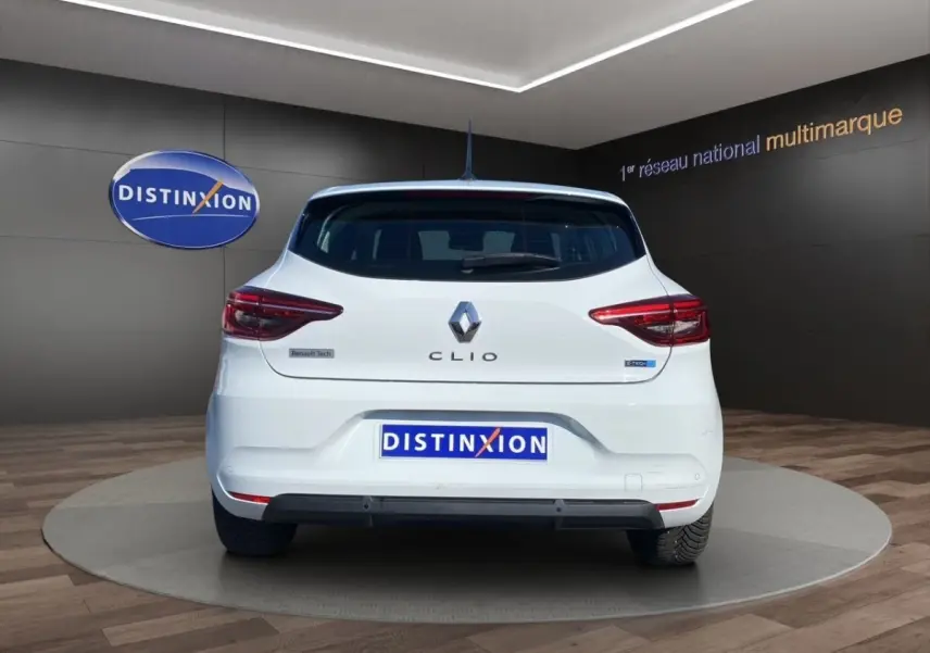 Vue arrière d'une Renault Clio blanche Business Réversible E-TECH 140 avec feux LED et logo visible sur fond showroom.