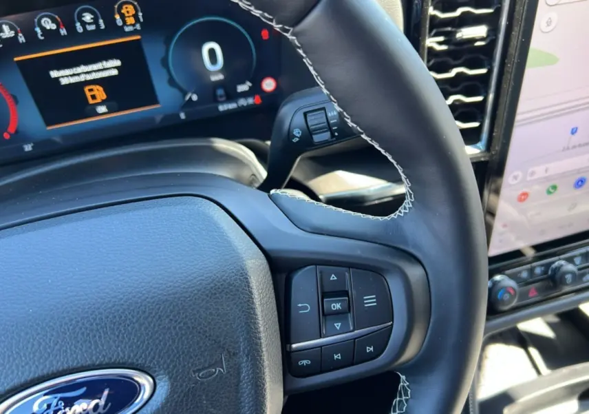 Gros plan sur le volant cuir multifonctions et tableau de bord numérique du Ford Ranger noir agate 2025.
