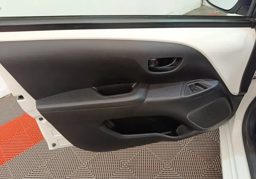 Intérieur côté gauche de porte avant blanche de Peugeot 108 2020, avec commande de vitre et poignée noire.