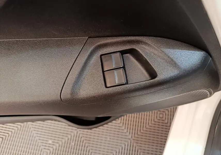 Gros plan sur les commandes des vitres électriques côté conducteur d’une Peugeot 108 blanche, version 2020.
