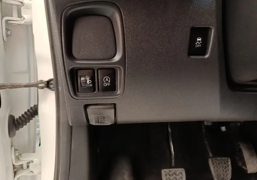 Vue rapprochée des commandes sous le tableau de bord côté conducteur d’une Peugeot 108 blanche, 2020.