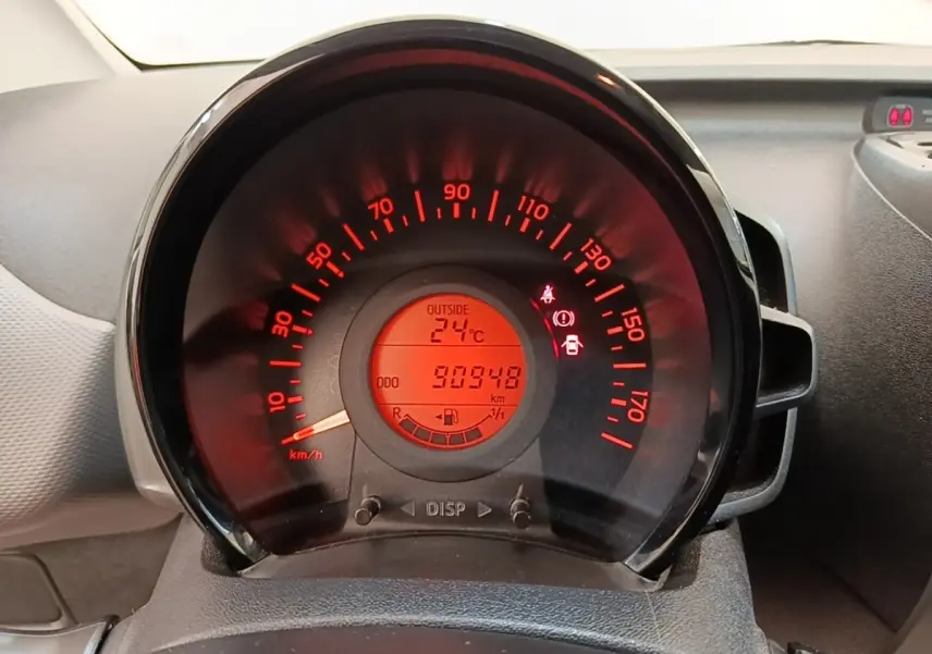 Gros plan sur le compteur de vitesse rouge de la Peugeot 108 blanche, affichant 30 948 km et 24°C extérieur.