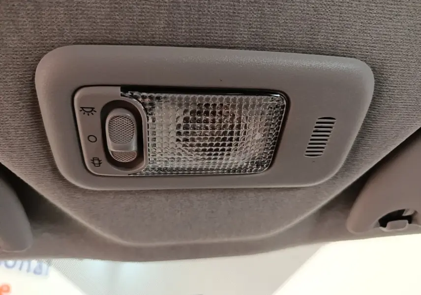 Plafonnier intérieur gris avec interrupteur de lumière, vue en gros plan du toit d'une Peugeot 108 blanche.