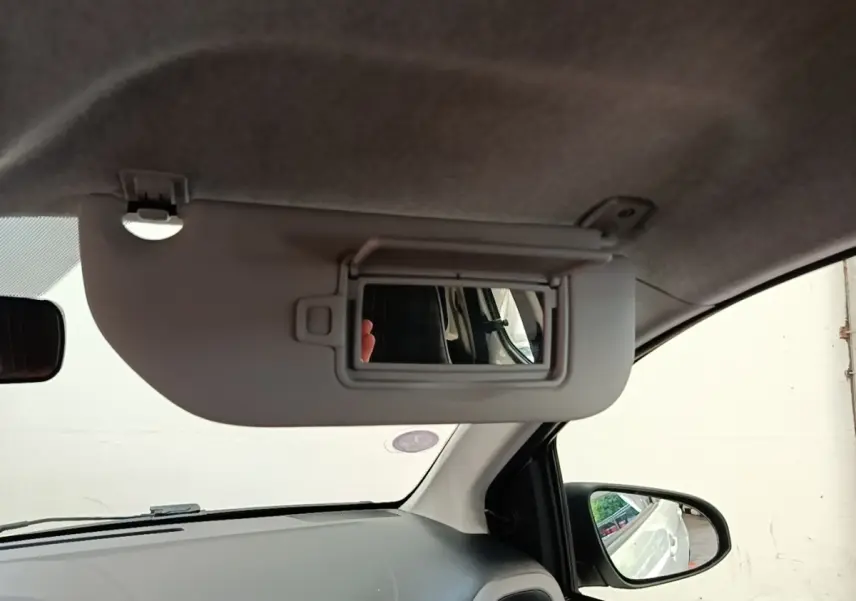 Intérieur du Peugeot 108 blanc 2020, vue côté conducteur sur pare-soleil avec miroir et rétroviseur extérieur.