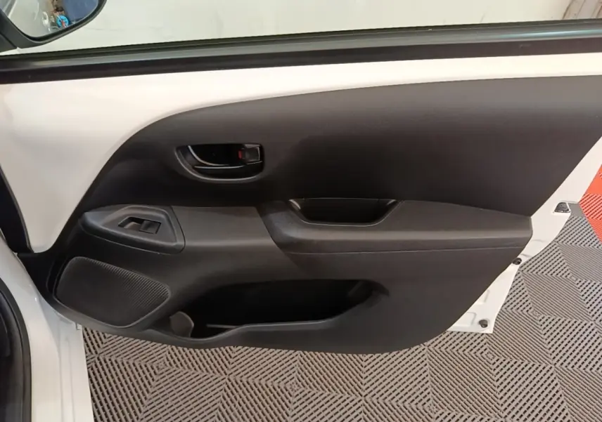 Vue intérieure de la porte avant gauche blanche d’une Peugeot 108 VTI 72 S&S Active avec commandes de vitre et poignée noire.