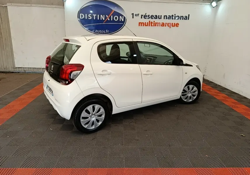 Peugeot 108 blanc vue de profil droit en intérieur, avec jantes acier et vitres teintées.