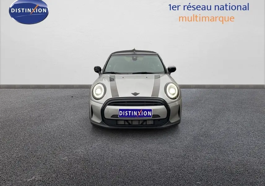 Vue frontale d'une MINI Cabriolet 2023 Melting Silver Metal avec bandes noires et phares allumés.