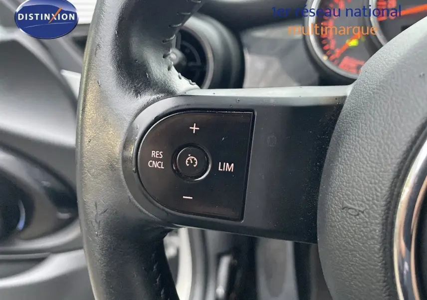 Gros plan sur la commande de régulateur de vitesse au volant en cuir noir du MINI Cabriolet Melting Silver 2023.