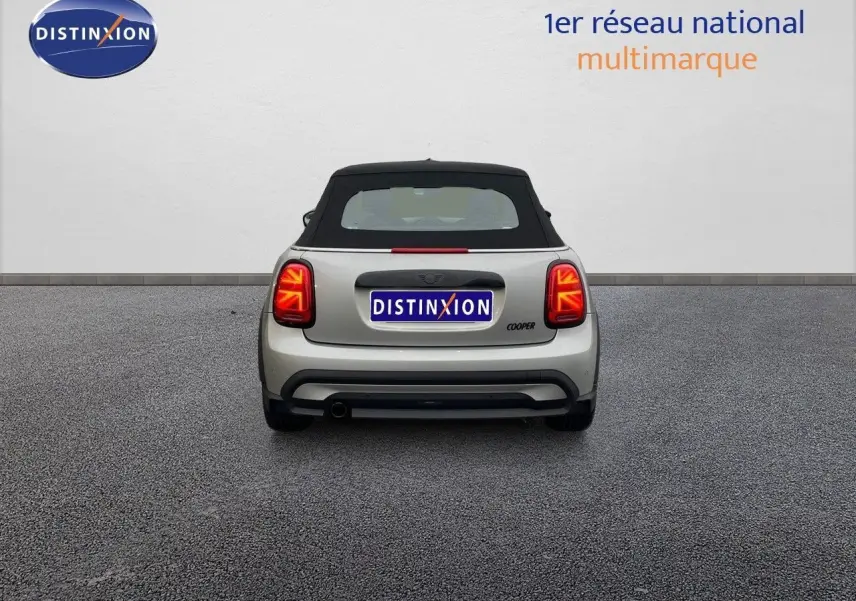 Vue arrière d'une MINI Cabriolet F57 Melting Silver avec toit noir relevé et feux arrière allumés.