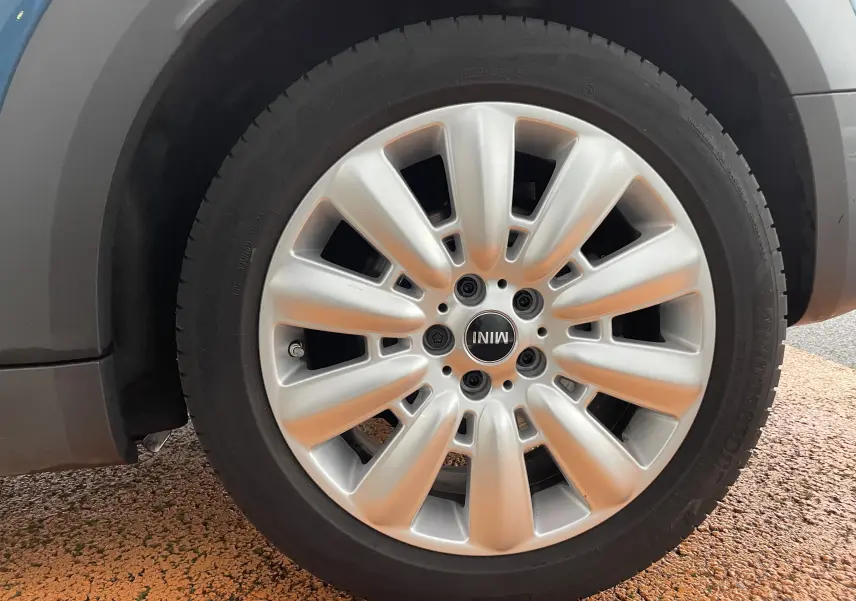 Gros plan sur la jante argentée du côté avant gauche d'une MINI Countryman bleu Island Metal de 2019.
