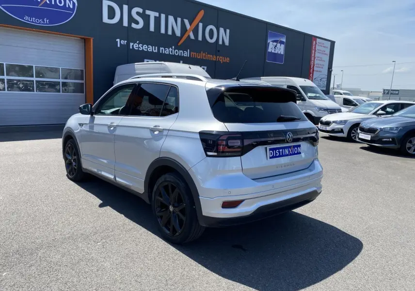 Vue 3/4 arrière droite du Volkswagen T-Cross R-Line 2022 en reflet d'argent métallisé avec jantes noires et vitres surteintées.