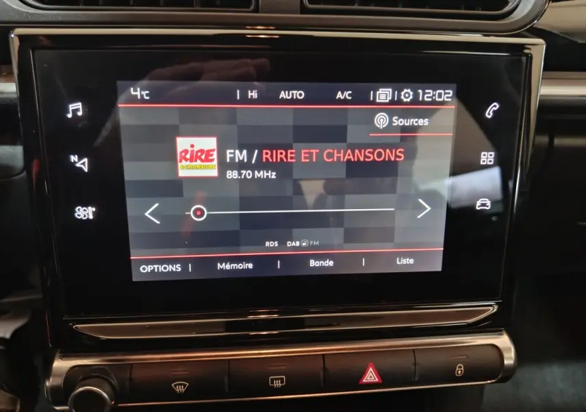 Écran tactile central de la Citroën C3 2024 noir affichant la radio FM sur fond sombre avec commandes tactiles.