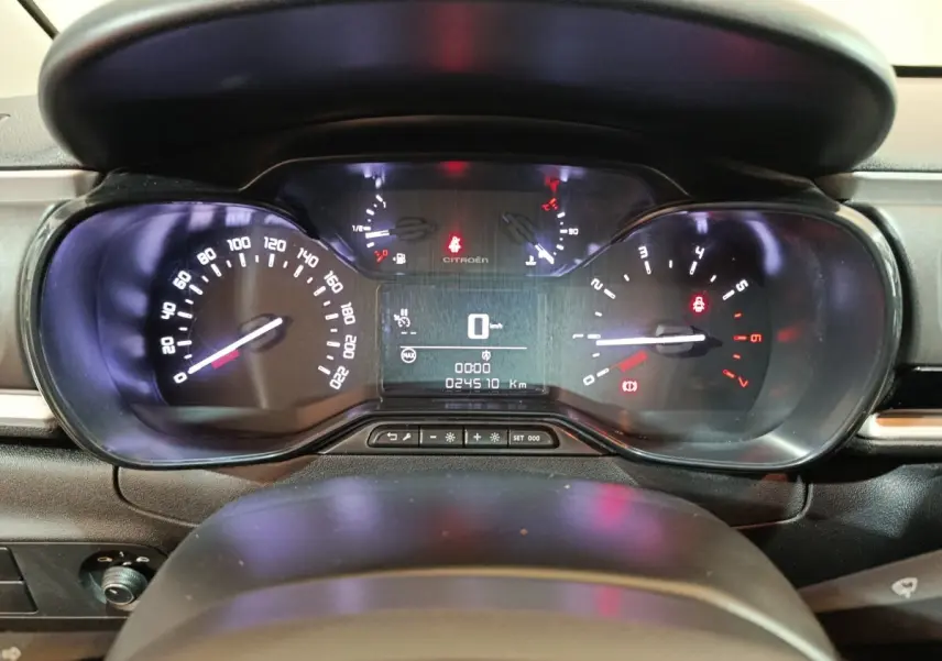 Vue rapprochée du tableau de bord noir de la Citroën C3 2024, affichant la vitesse à 0 km/h et les voyants allumés.
