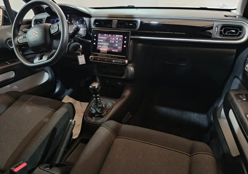 Vue intérieure côté conducteur de la Citroën C3 2024 noire, avec tableau de bord tactile et volant multifonctions.