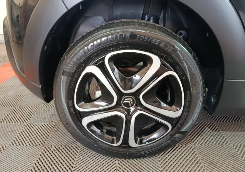 Gros plan sur la roue avant droite noire d'une Citroën C3 2024 avec jante alliage au design moderne.