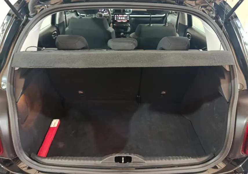 Vue arrière du coffre ouvert d'une Citroën C3 noire 2024, montrant l'intérieur spacieux et la tablette cache-bagages.