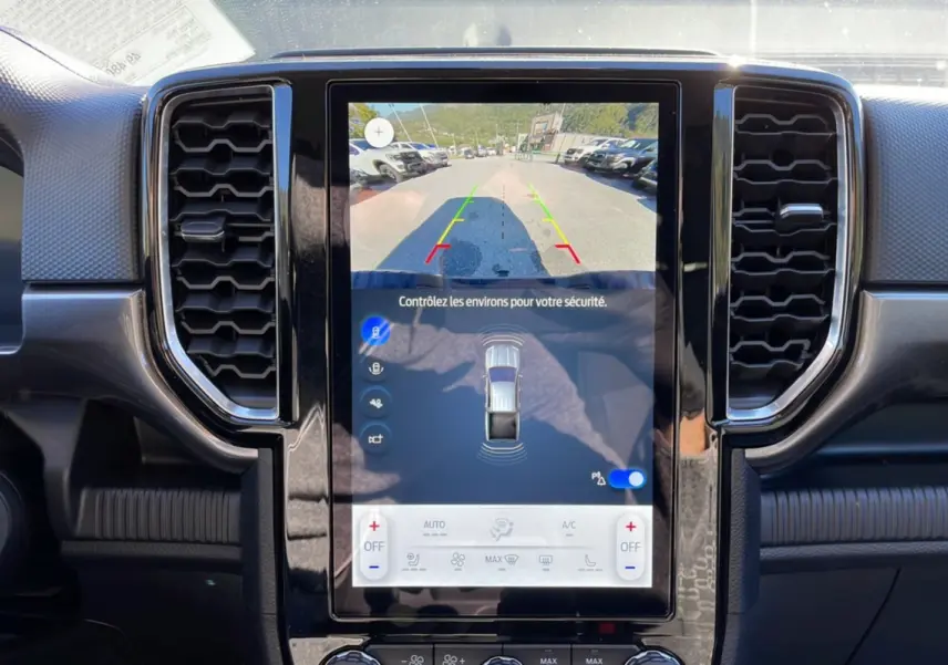 Vue rapprochée de l’écran tactile central du Ford Ranger gris Iconic 2025 avec caméra de recul et commandes climatisation.