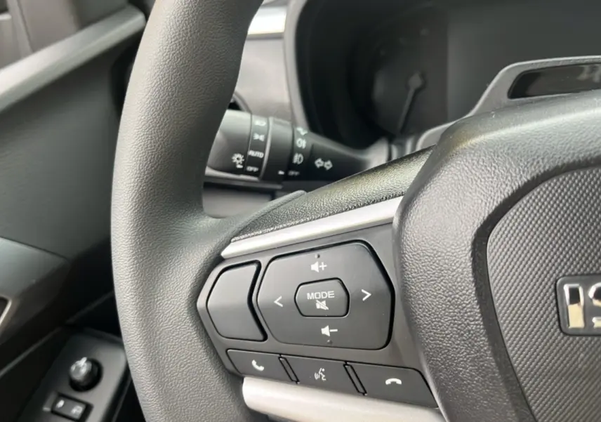 Gros plan sur le volant multifonctions noir de l'Isuzu D-MAX 2026, avec commandes audio et téléphone intégrées.