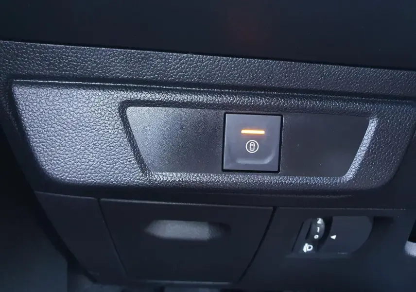Gros plan sur le bouton de condamnation électrique des portes dans l'habitacle de la Dacia Sandero gris urbain 2024.