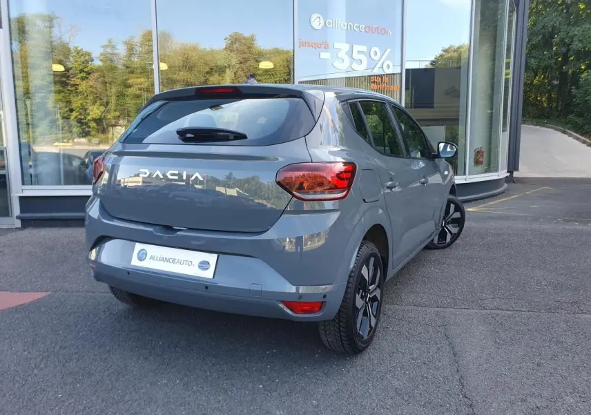 Vue 3/4 arrière droite d'une Dacia Sandero 2024 gris urbain avec jantes alu 16 pouces et feux arrière LED.