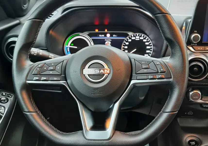 Vue rapprochée du volant en cuir noir du Nissan Juke 2024 avec tableau de bord numérique et commandes intégrées.