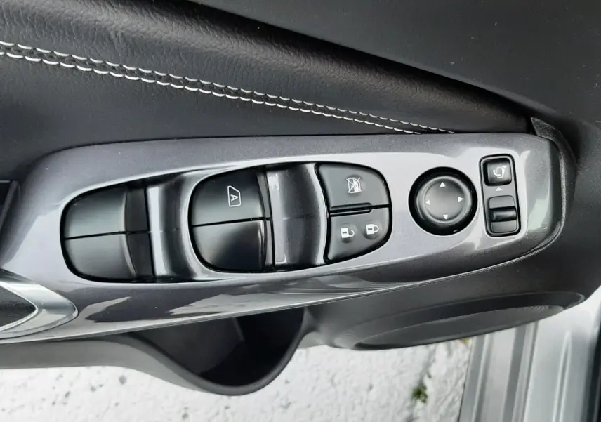 Panneau de commandes des vitres et rétroviseurs côté conducteur du Nissan Juke gris perle métal 2024.