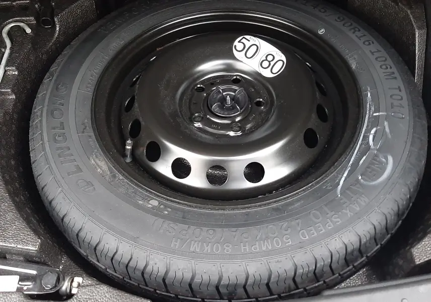 Roue de secours compacte noire dans le coffre d'un Nissan Juke gris perle 2024, version hybride N-Connecta