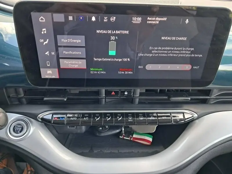 Tableau de bord de Fiat 500C 2021 vert foncé, affichage numérique de la batterie et commandes climatisation visibles.