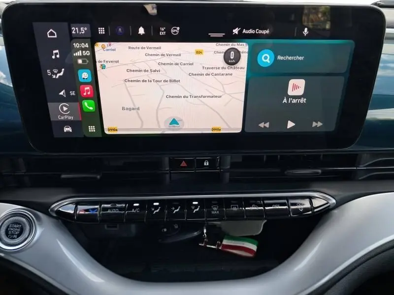 Vue rapprochée de l'écran tactile et des commandes du tableau de bord de la Fiat 500C 118 cv icone vert foncé métal 2021 électrique.