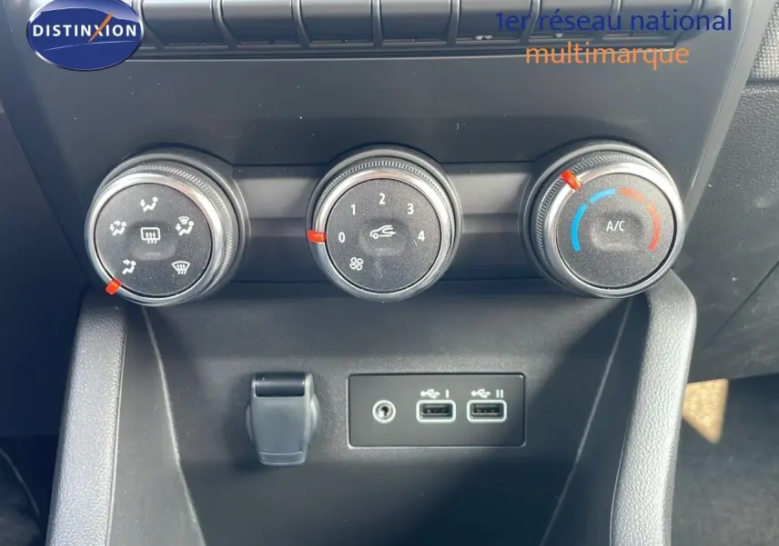 Commandes de climatisation et deux ports USB sur la console centrale d'une Renault Clio noire étoile métal 2025.
