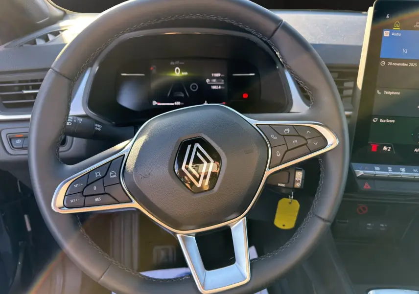 Vue intérieure centrée sur le volant du Renault Captur 2024, avec commandes intégrées et tableau de bord digital.