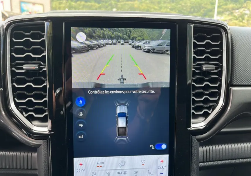 Écran central tactile du Ford Ranger gris carbone montrant la caméra de recul et l'interface de stationnement assisté.