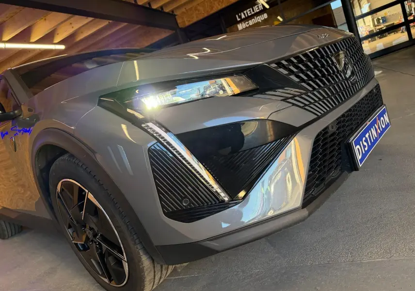 Vue 3/4 avant droit d'une Peugeot 408 gris Selenium avec calandre noire et jantes alliage 19'' diamantées.