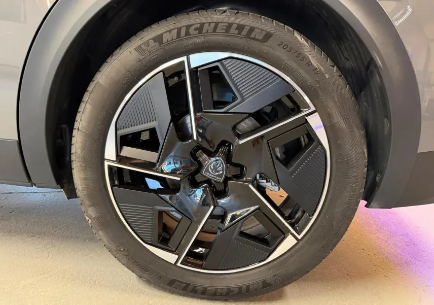 Gros plan sur la jante alliage 19'' diamantée graphite du Peugeot 408 gris, avec logo Peugeot central visible.