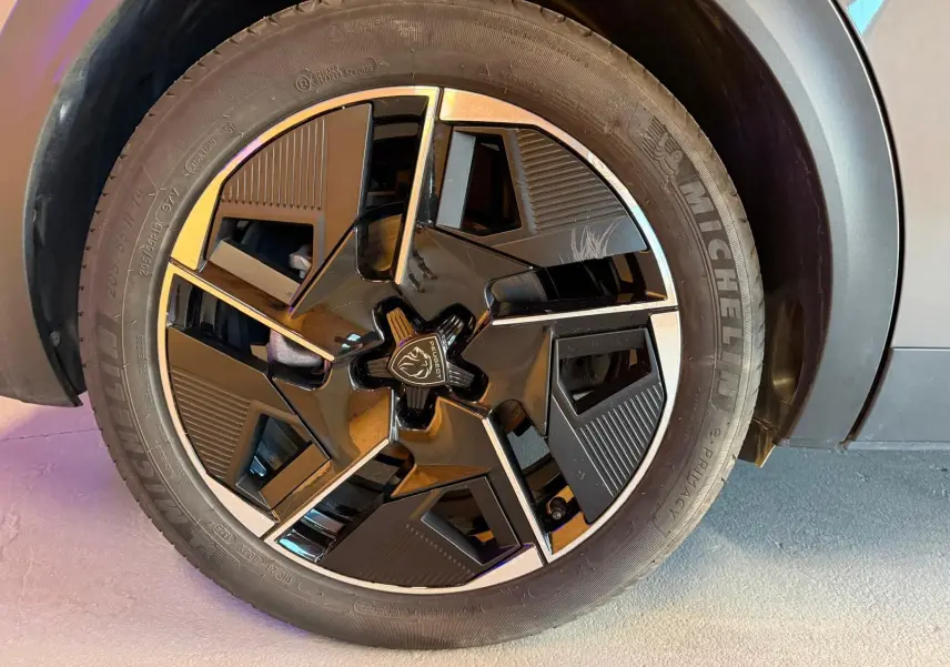 Gros plan sur la jante alliage 19'' diamantée graphite du Peugeot 408 gris, avec logo lion au centre.