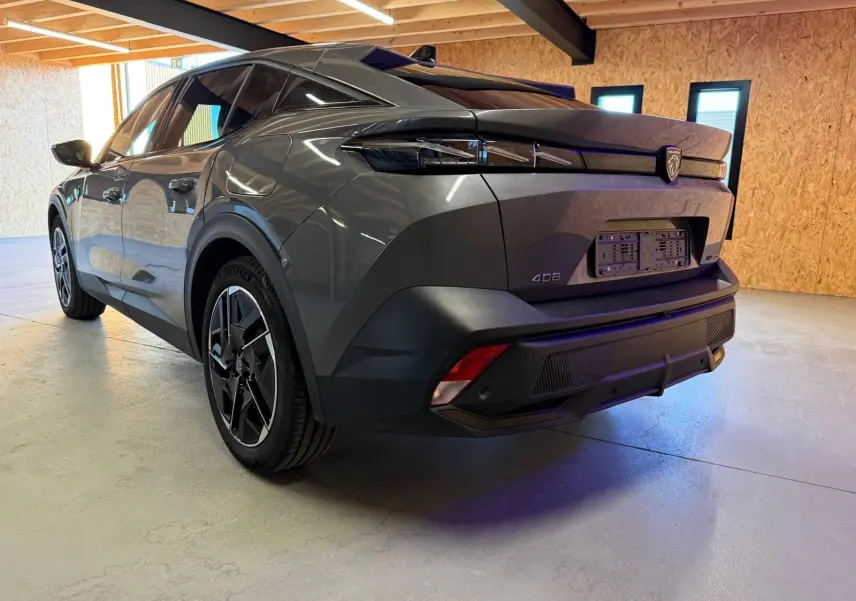 Vue 3/4 arrière droite d'une Peugeot 408 gris selenium avec jantes 19'' diamantées graphite dans un garage.