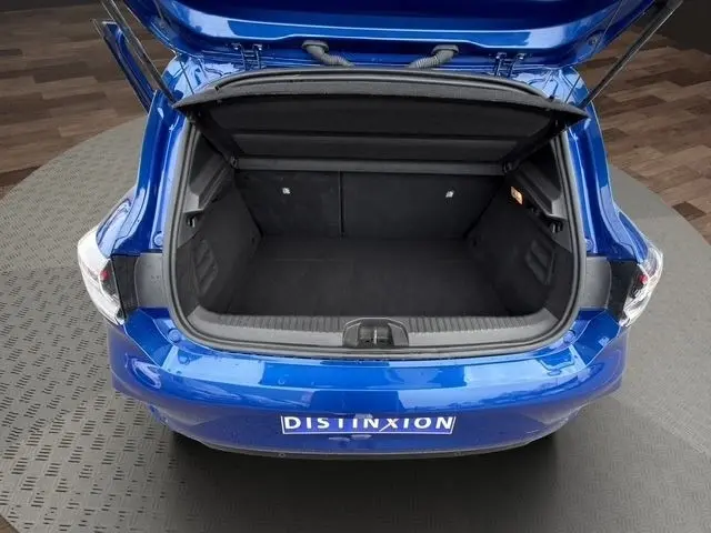 Vue arrière ouverte du coffre bleu de la Renault Clio Techno E-Tech 2025, montrant un espace de chargement spacieux et propre.