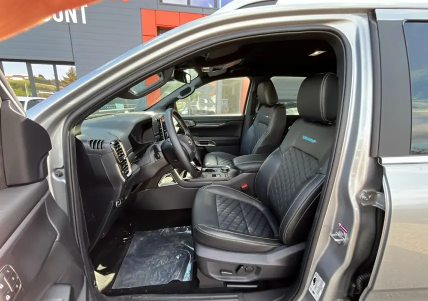 Vue intérieure côté conducteur du Ford Ranger gris iconic 2026, sièges cuir noirs avec surpiqûres et logo Platinum Rideau.