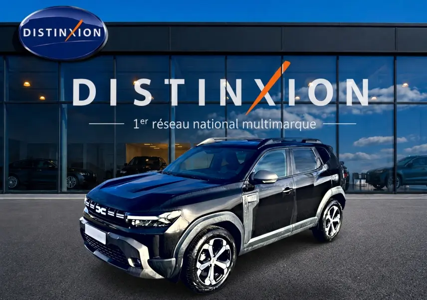 Dacia Duster noir vue 3/4 avant droit, avec jantes alu et barres de toit devant showroom Distinxion.