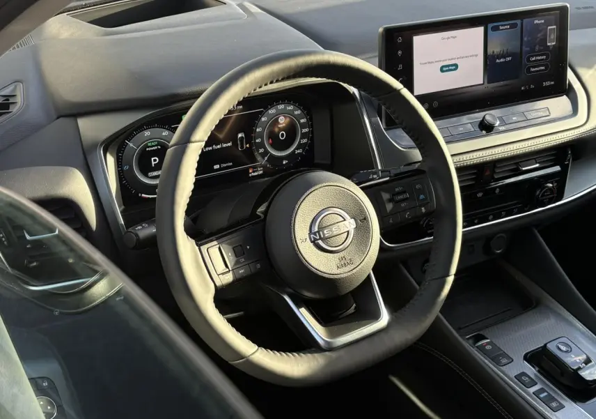 Vue intérieure côté conducteur du Nissan Qashqai 2026, volant cuir noir et tableau de bord numérique avec écran tactile.
