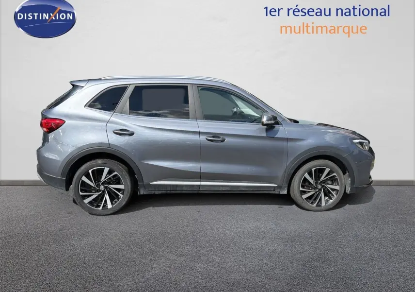 Vue de profil côté gauche du MG ZS 1.5L Hybrid+ 197ch Luxury en gris métallisé Hampstead, avec jantes alliage bicolores.