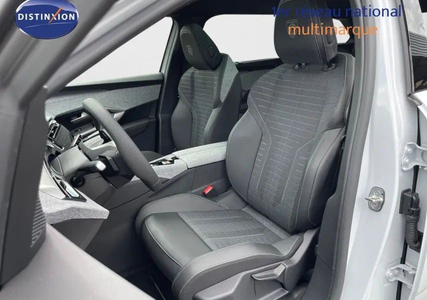 Vue intérieure côté conducteur du Peugeot 5008 Hybrid 2025 avec sièges gris en tissu et cuir contrasté.