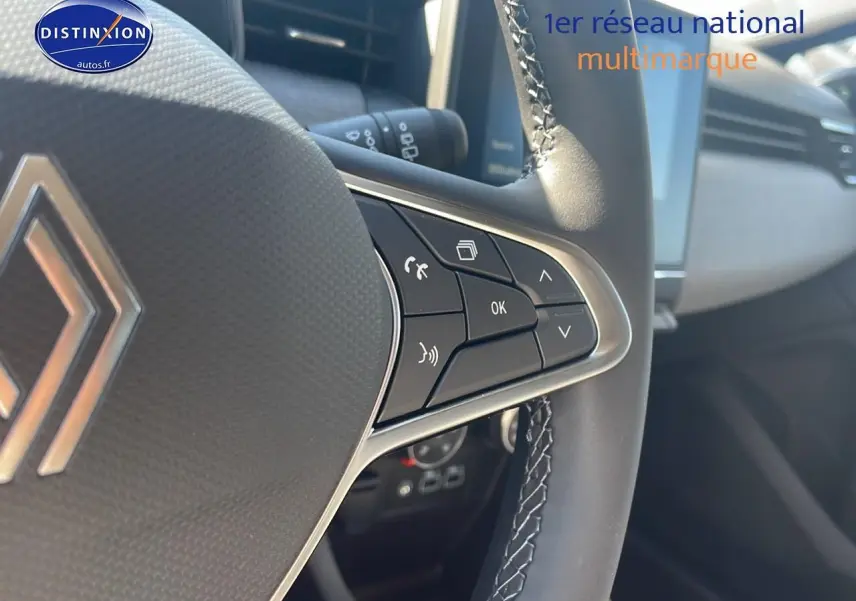 Gros plan sur les commandes du volant multifonction d'une Renault Clio V 1.5 Blue dCi 100 Evolution, intérieur moderne.