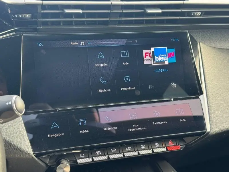 Écran tactile central du tableau de bord de la Peugeot 308 2024, affichant les menus navigation et téléphone.