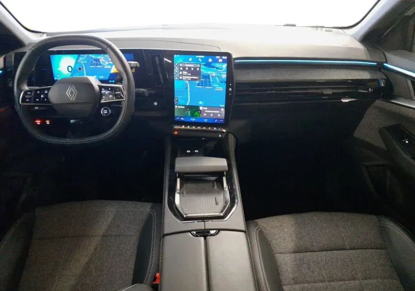 Vue intérieure avant du Renault Espace 2025 avec tableau de bord numérique, écran tactile vertical et ambiance lumineuse bleue.